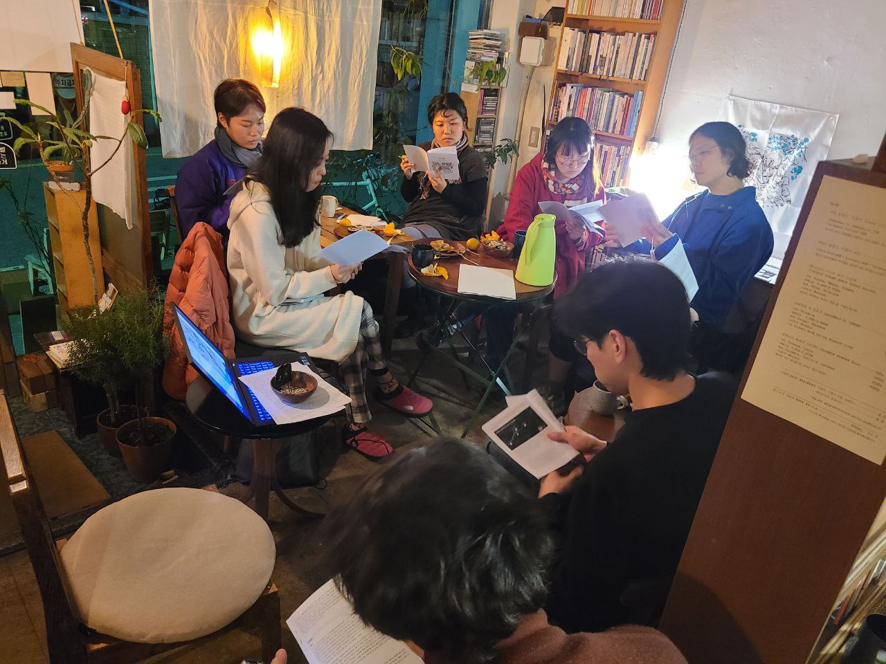 조명이 밝혀진 아늑한 실내에 여섯 명의 사람들이 각각 손에 소책자를 들고 읽고 있다. 